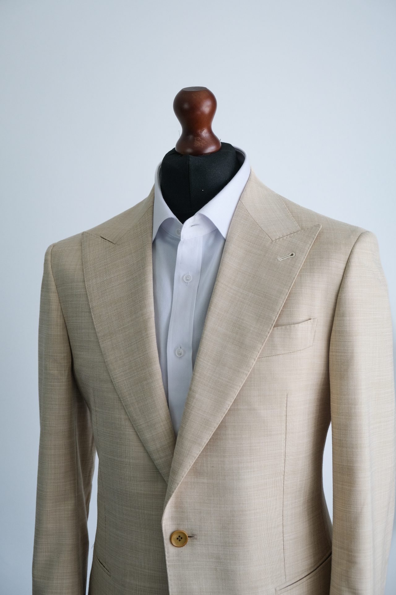 Tailor measuring a suit jacket on a mannequin