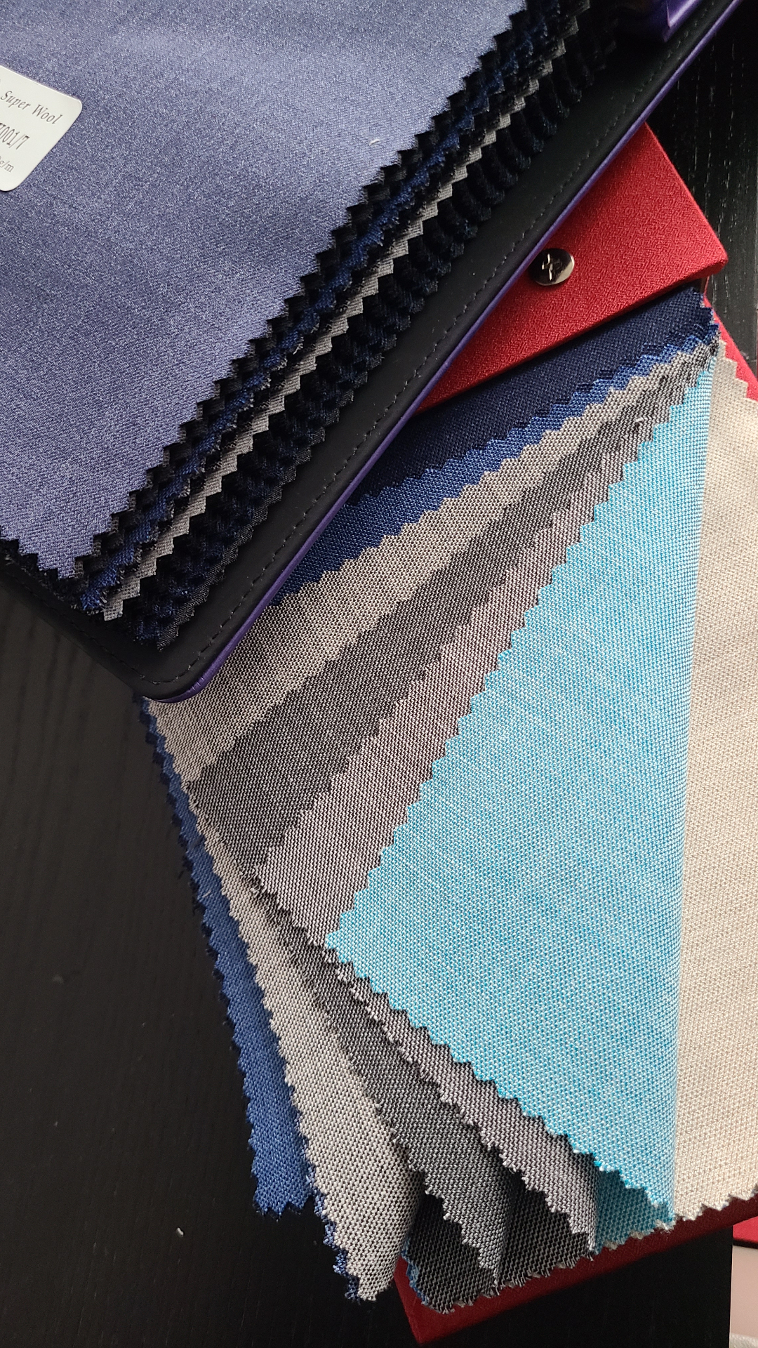 Row of bespoke suit jackets on wooden hangers