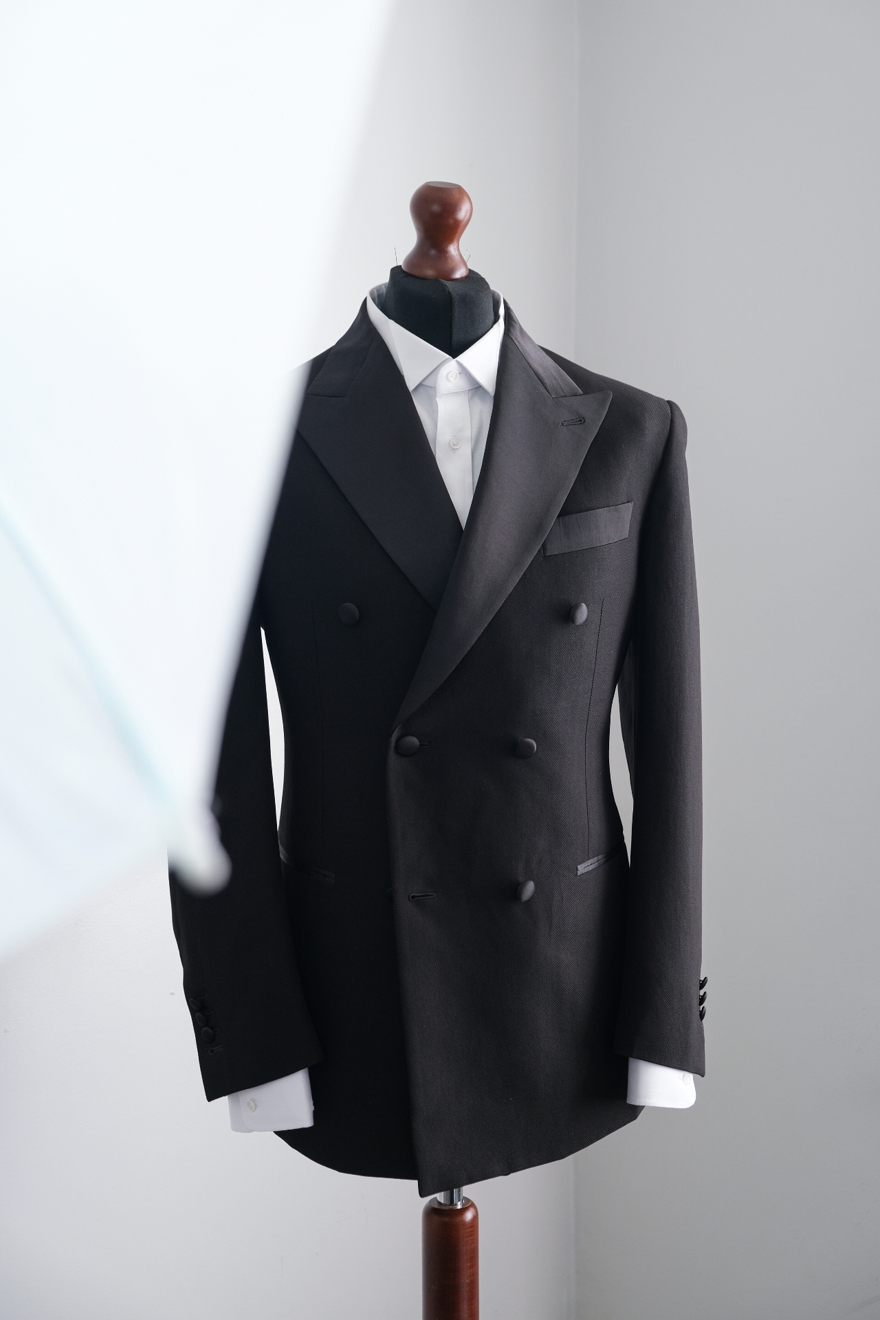 Dark double-breasted dinner jacket over a white shirt